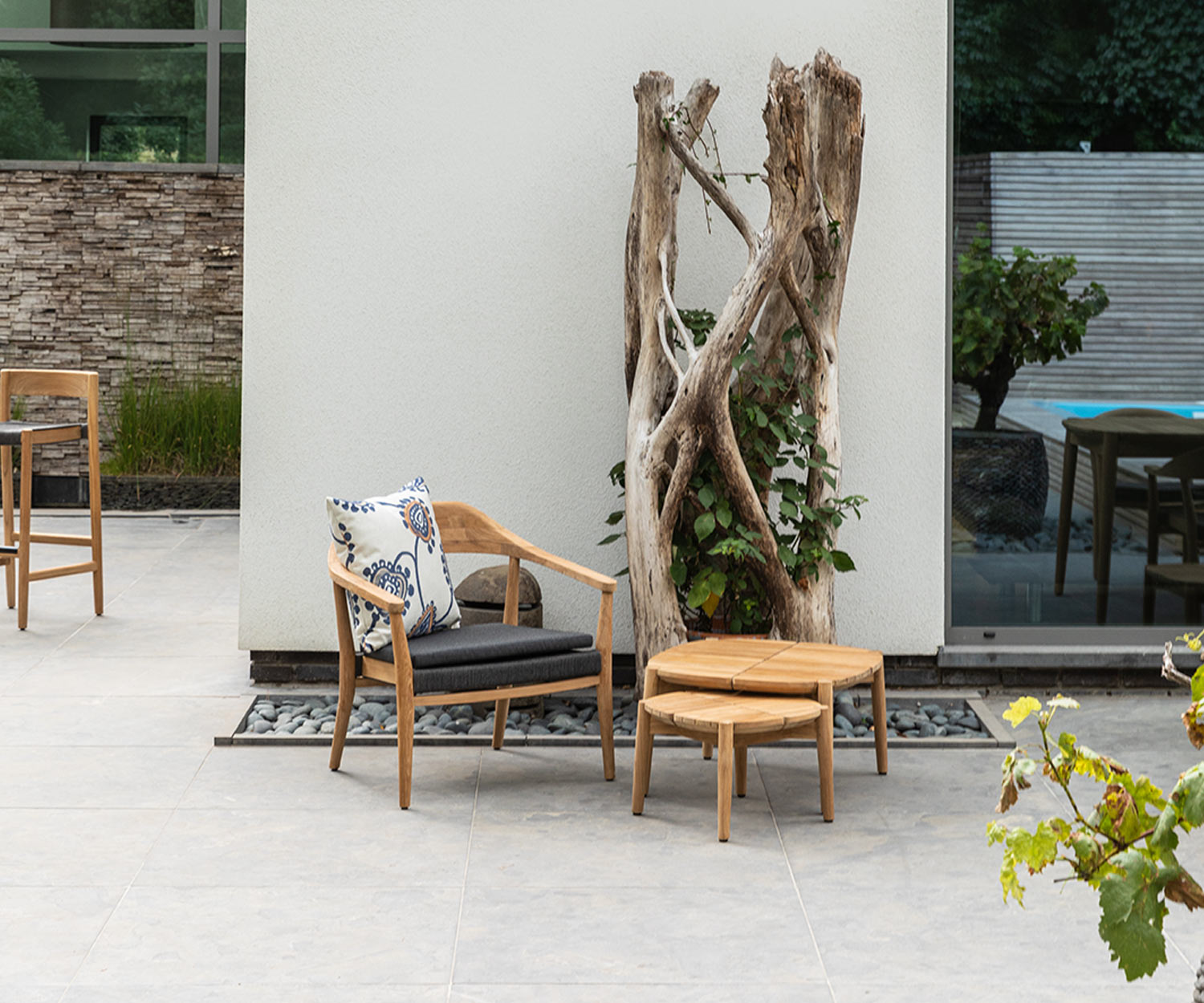 Tavolo quadrato da esterno Oasiq Copenhagen con sedia e albero in terrazza