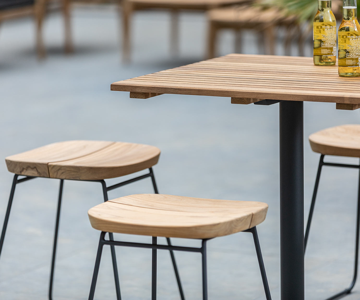 Bryggen Garten Hocker von Oasiq mit Tisch auf einer Terrasse