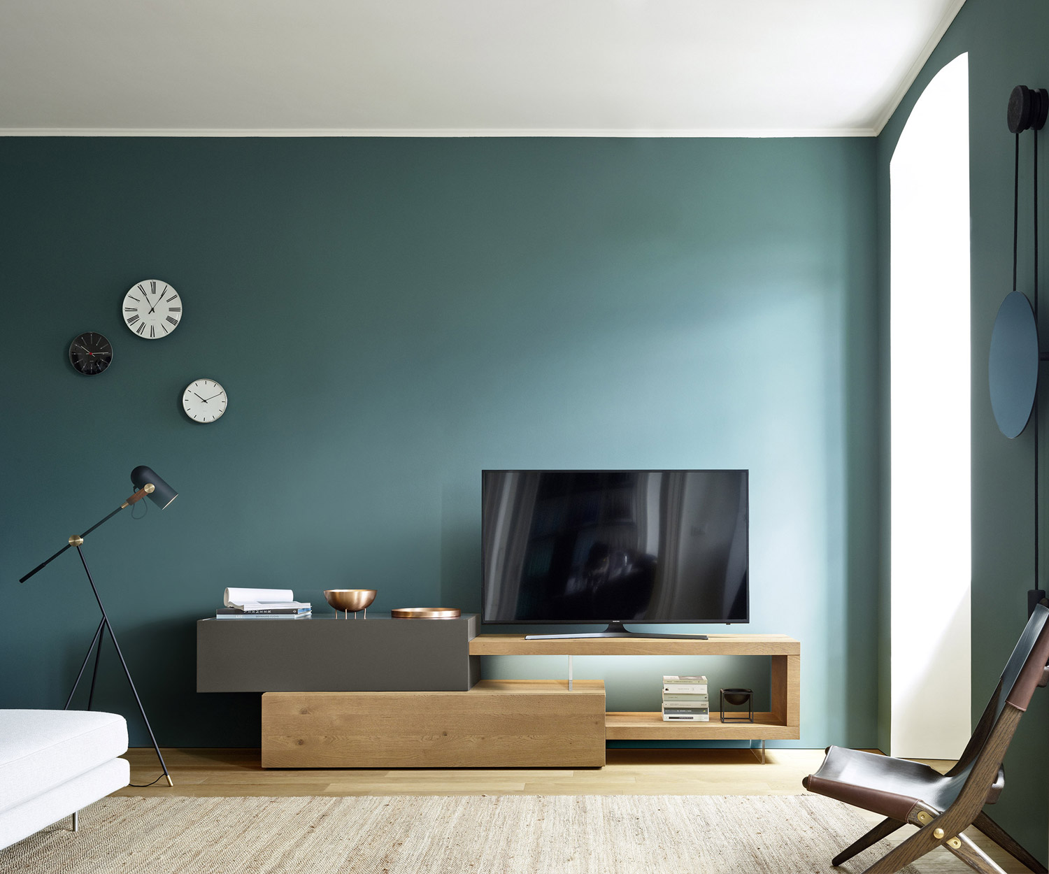 Moderne Wohnwand mit Bodenbank f&uuml;r TV und transparentem Fu&szlig; f&uuml;r Schwebeeffekt