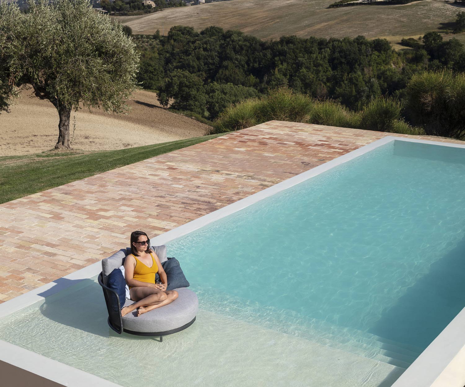 Salon de jardin résistant Baza Round de Todus avec pieds dans la piscine
